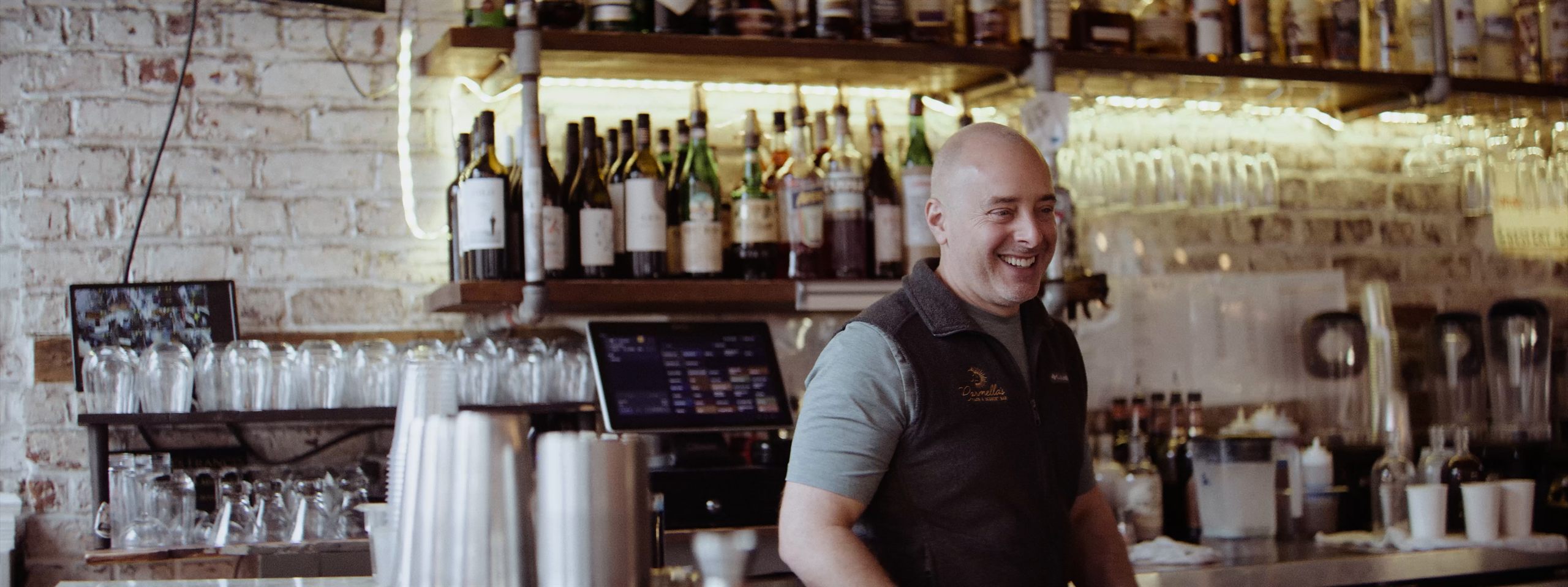 Carmella's Café owner behind the bar — still from the Carmella's spec piece