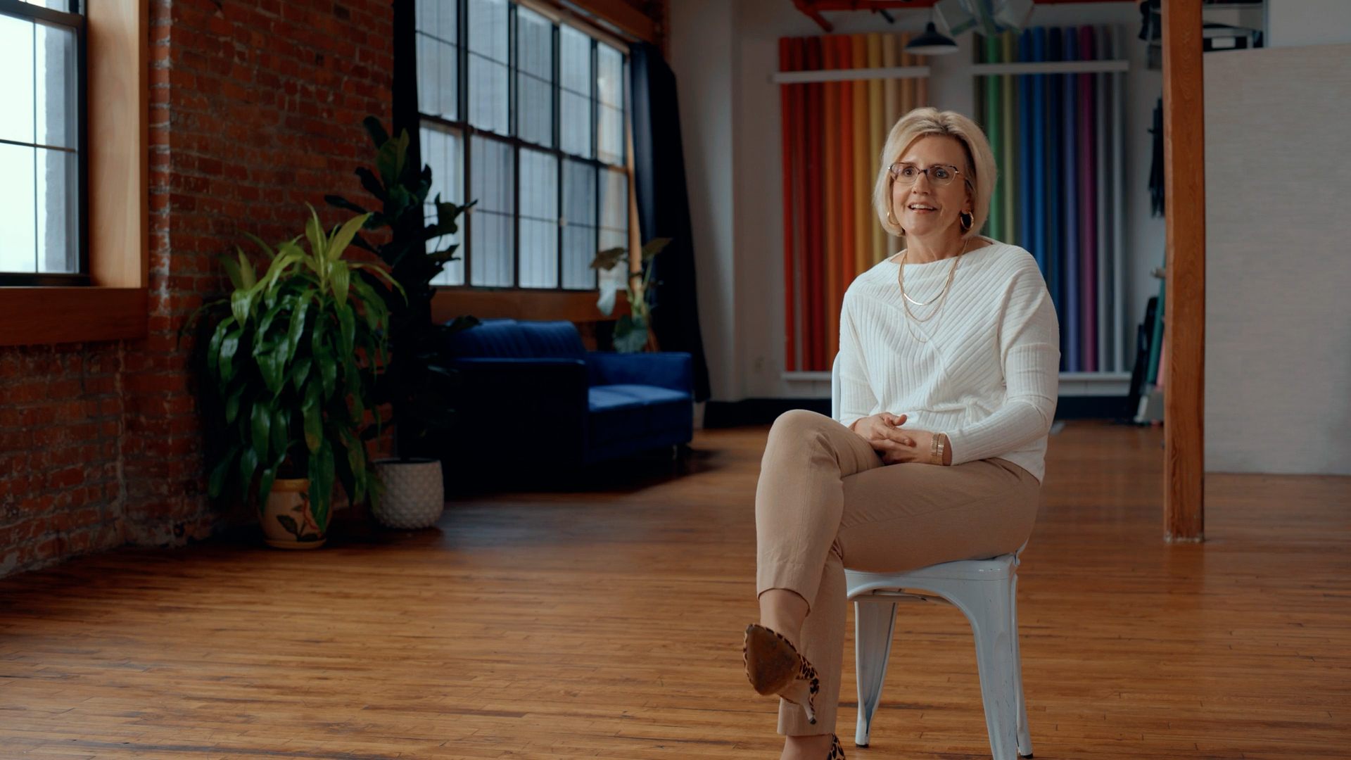 Executive interview subject seated on a chair in a sunlit Brooklyn loft — still from Kyndryl interview piece