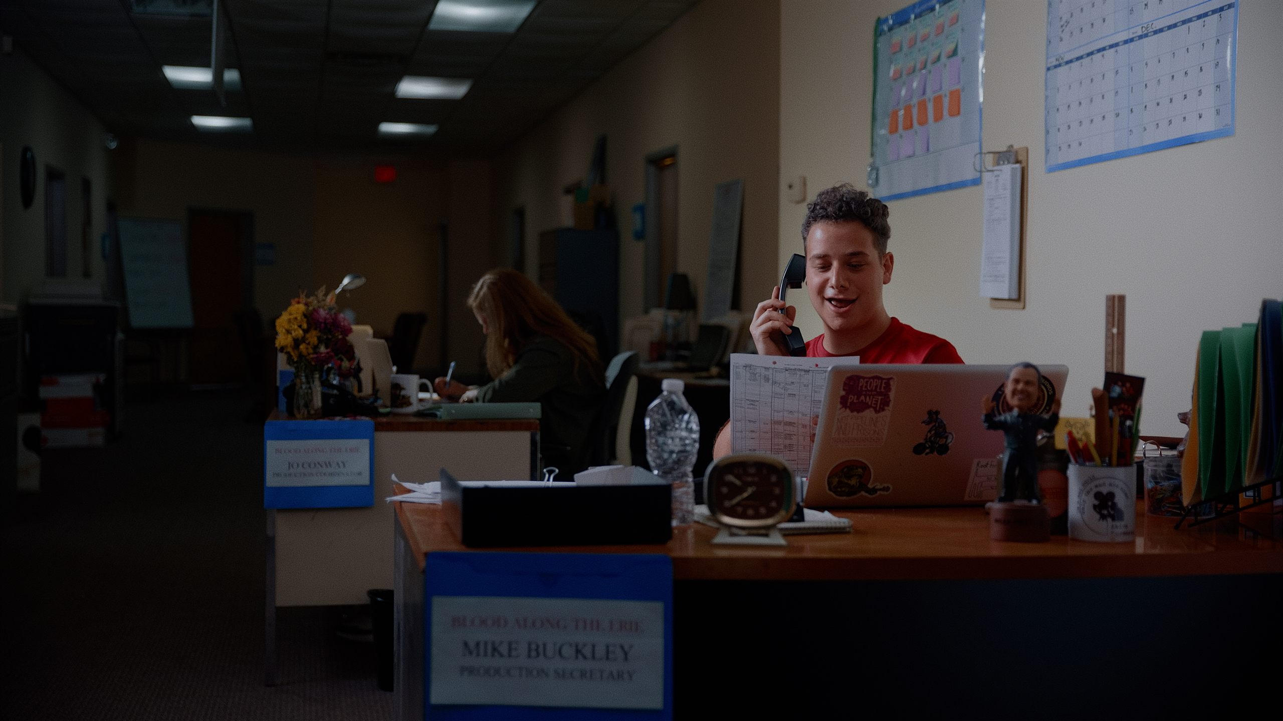 A young actor on the phone in a production office — still from Method to Their Madness
